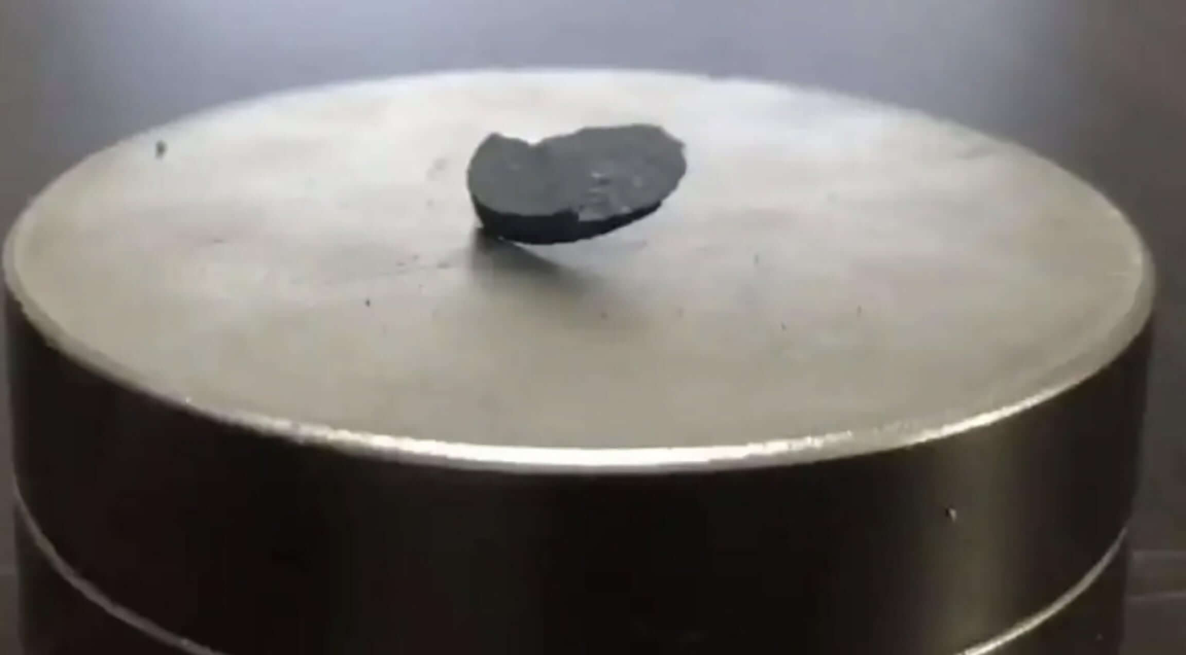 A piece of LK-99 partially levitating above a magnet.